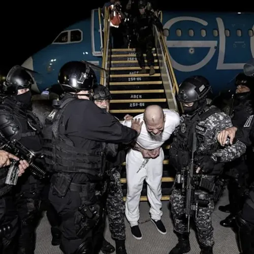 Salvadoran police officers escort alleged members of the Venezuelan gang Tren de Aragua