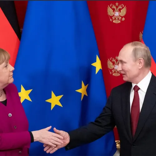 Russian President Vladimir Putin (R) shakes hands with German Chancellor Angela Merkel (L)