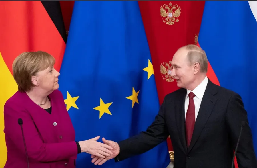Russian President Vladimir Putin (R) shakes hands with German Chancellor Angela Merkel (L)